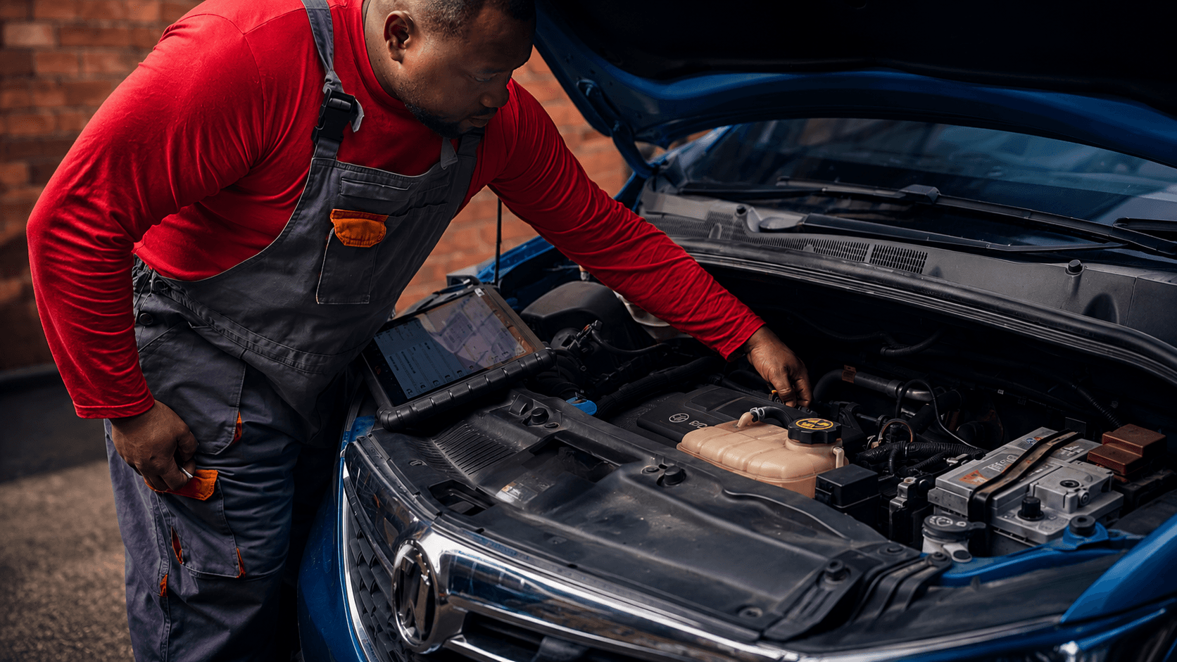 An SOB Autofix technician checking the engine bay of a blue car in the Doncaster workshop